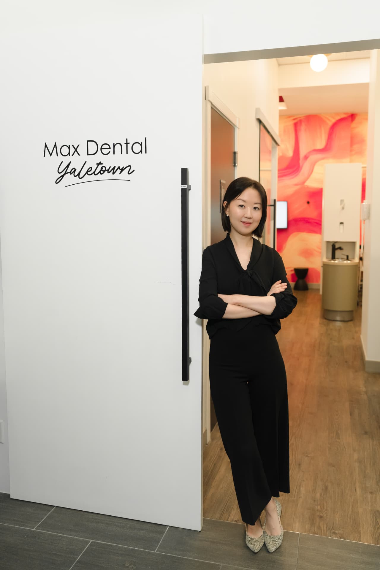Team member welcoming patients at the entrance of MAX Dental at Yaletown